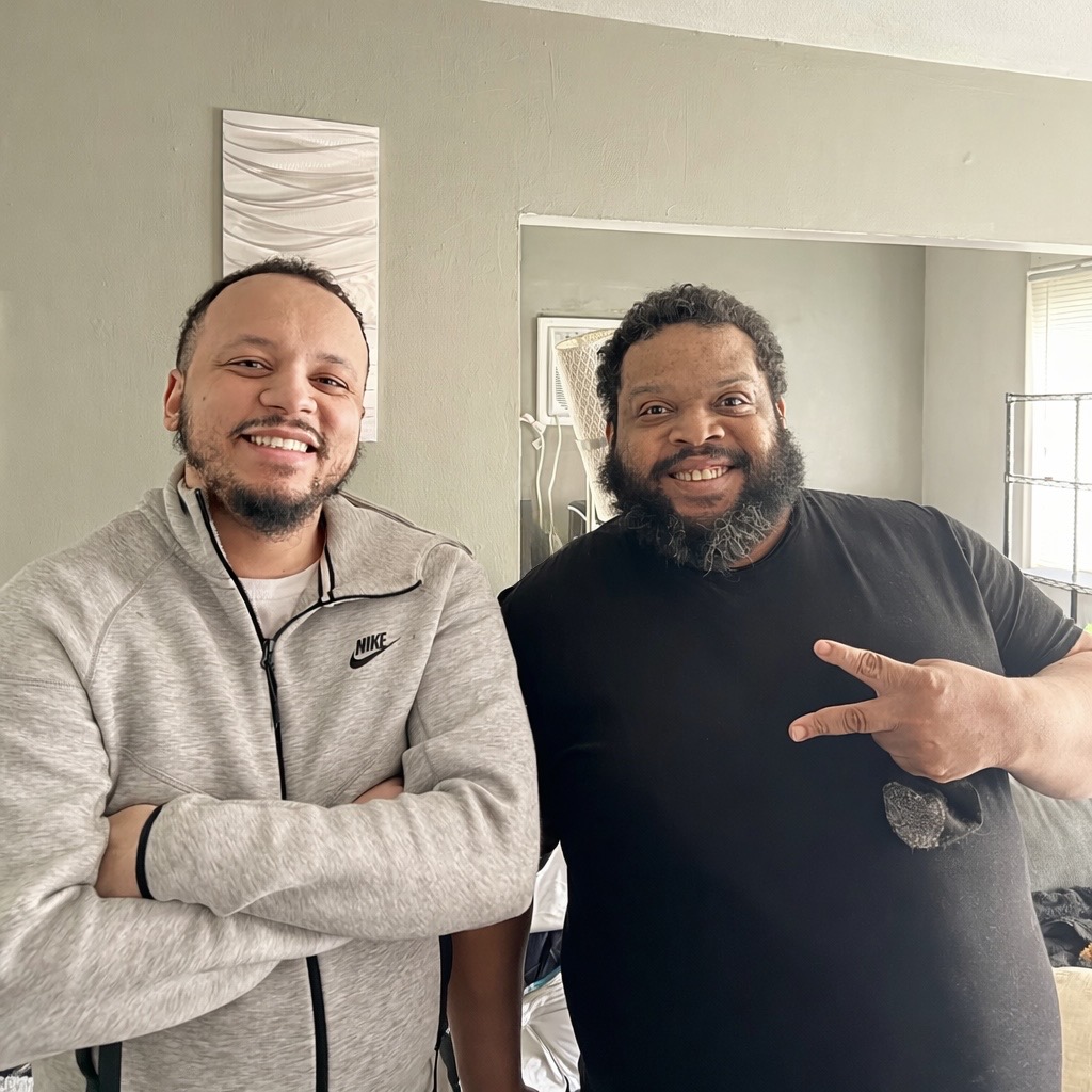 Two team members smiling together indoors